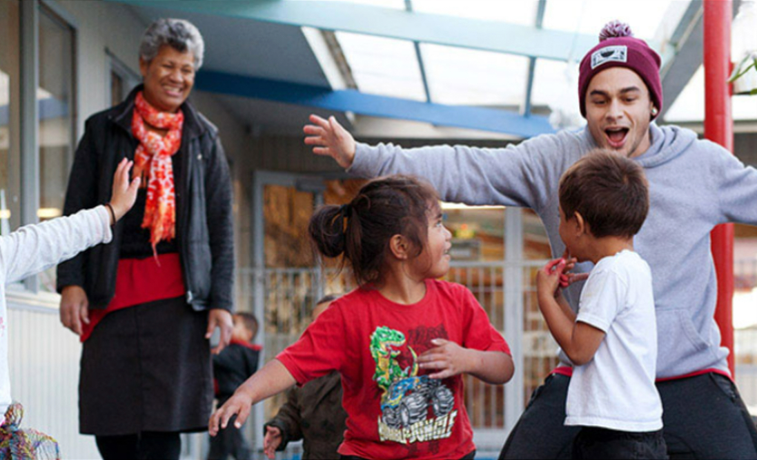 Man in red hat dancing with two little kids 