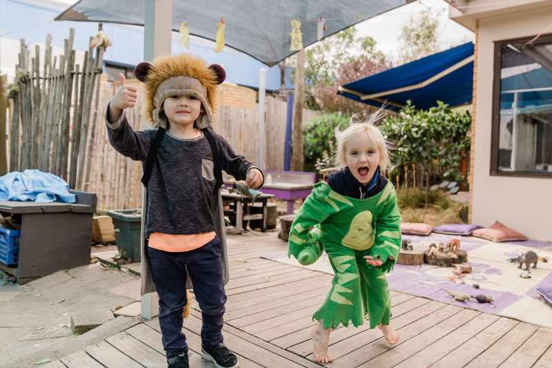 two kindergarten children playing on a deck