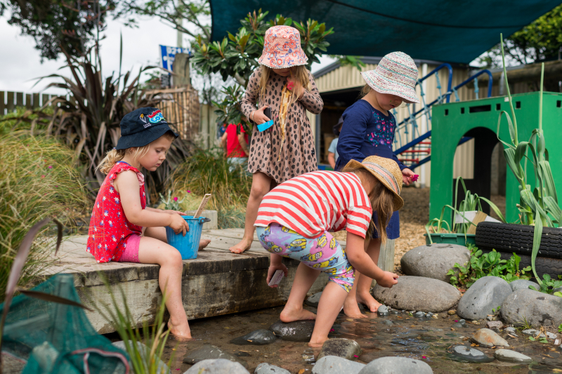 kindergarten children playing in green back yard