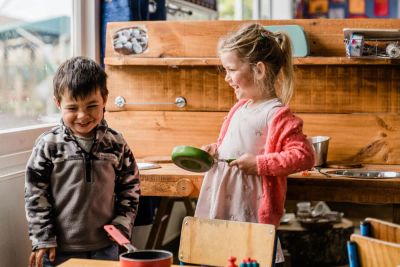 2 kids playing kitchens smiling